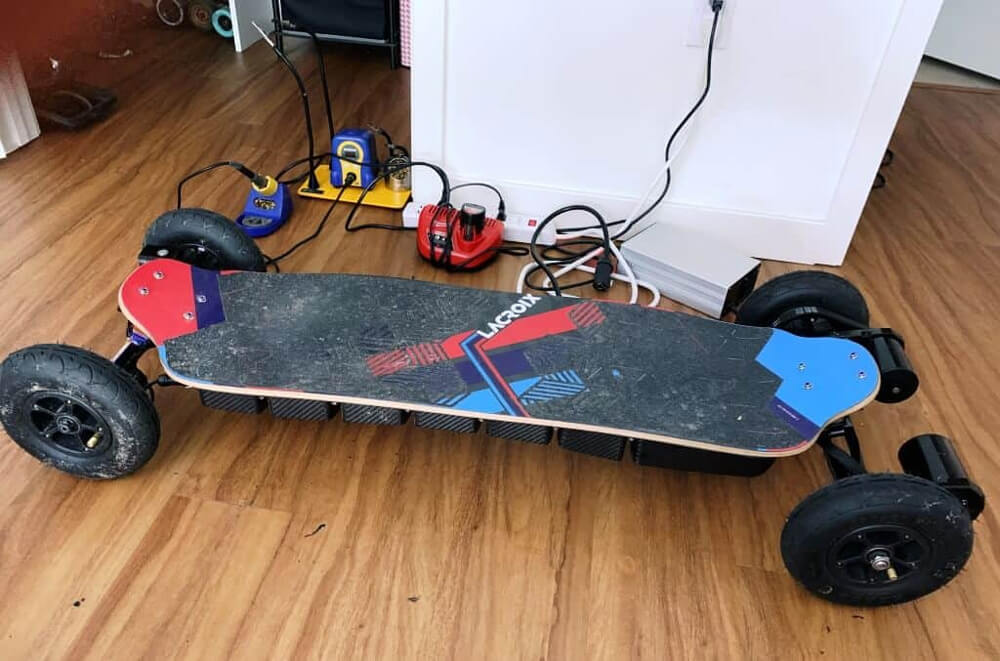 What is the formula or method to calculate the voltage of the electric skateboard battery