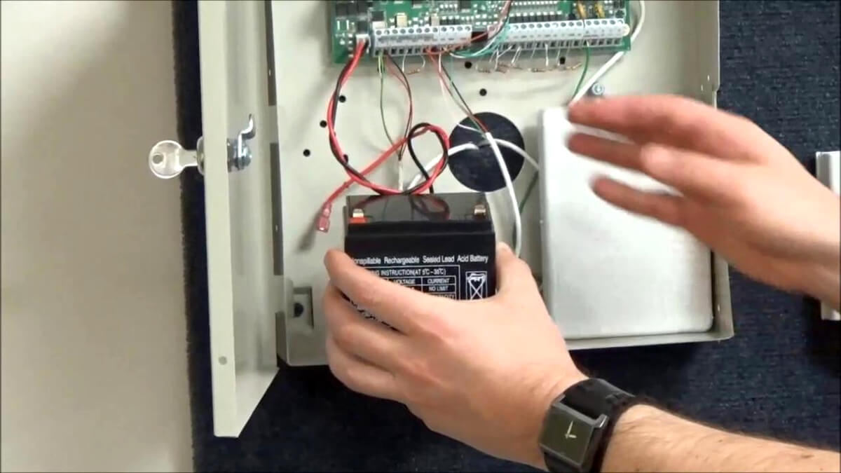 A Person installing an alarm system battery